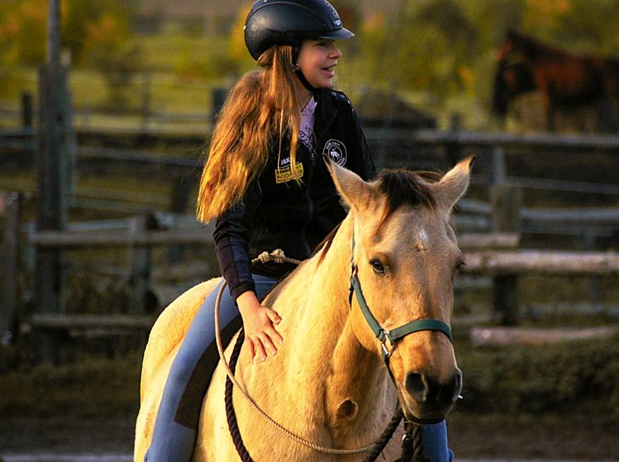 Mädchen auf hellem Pferd